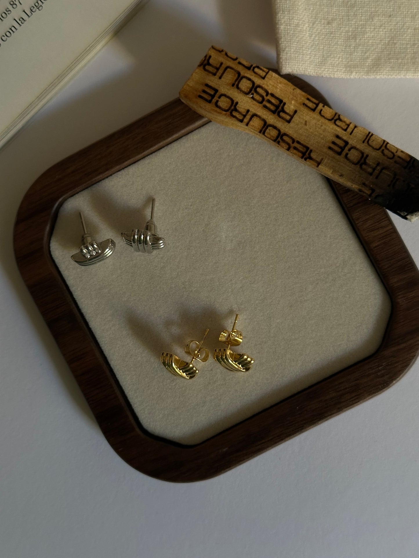 Pendientes pequeños en forma de cruz con textura oro