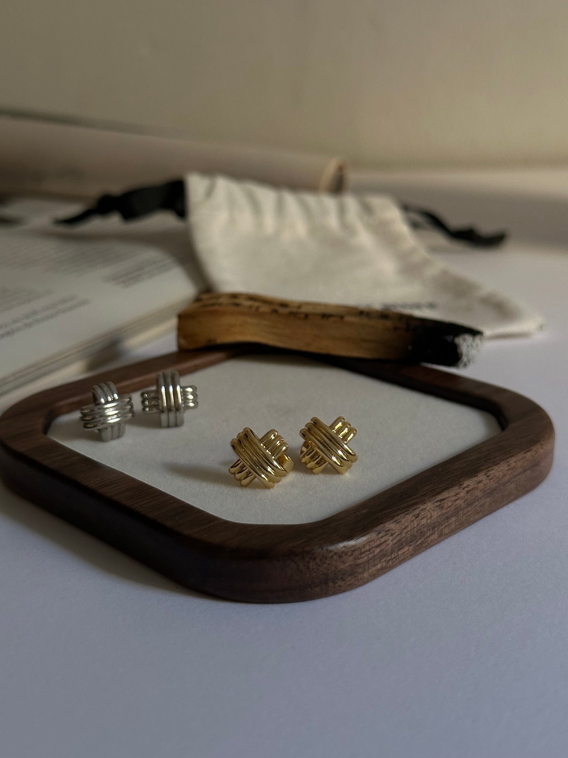 Pendientes pequeños en forma de cruz con textura oro