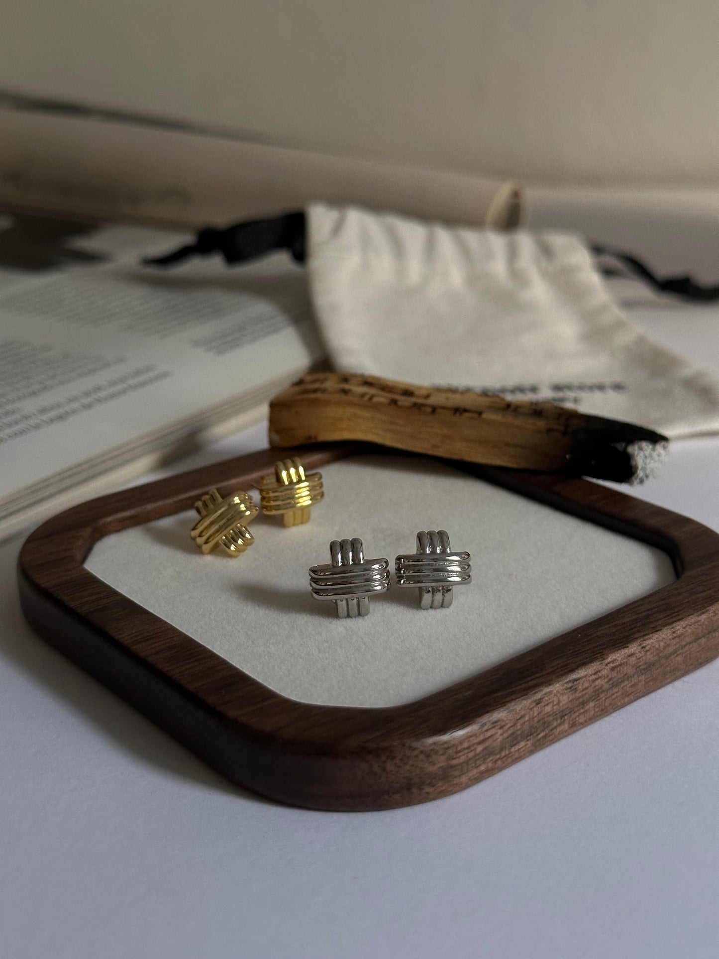 Pendientes pequeños en forma de cruz con textura plata