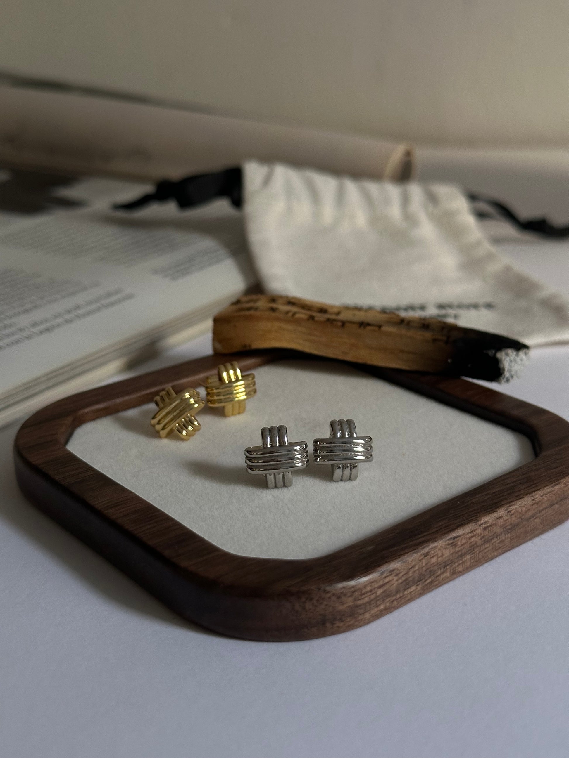 Pendientes pequeños en forma de cruz con textura plata